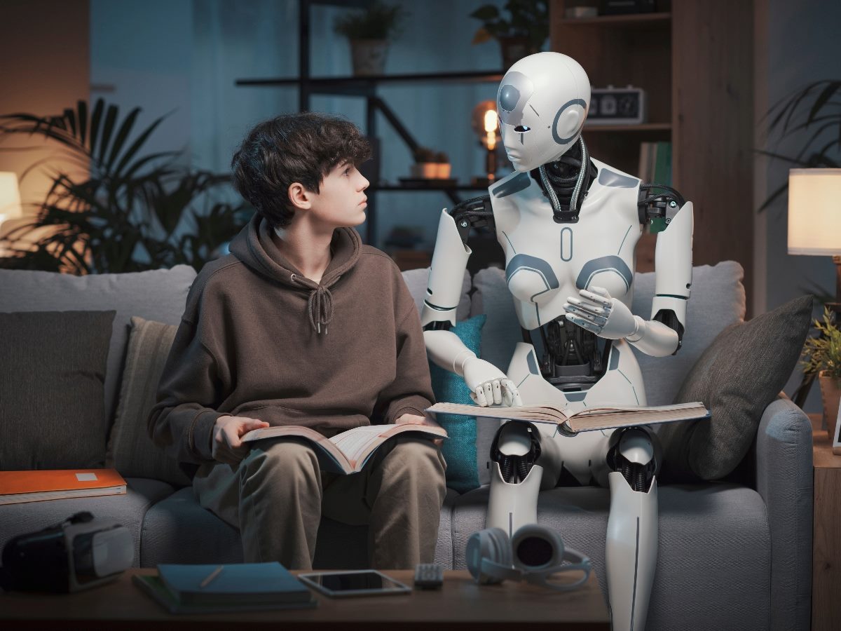 AI robot tutor reading with a teenage boy.