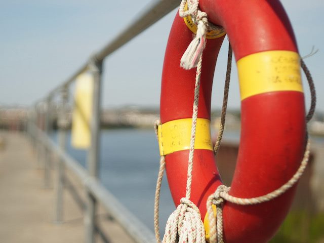 life preserver tied to a railing near water