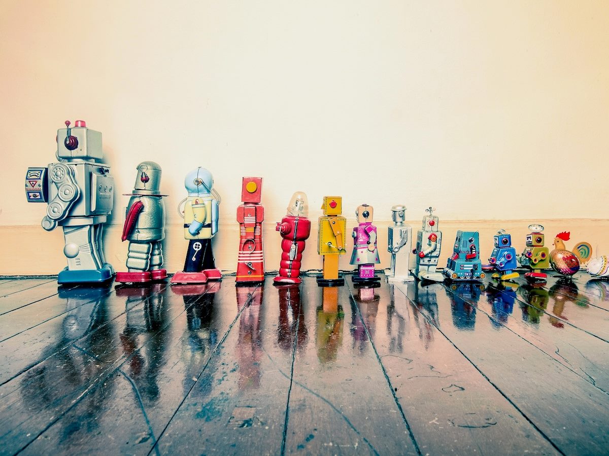 line up of vintage tin robot toys, from biggest to smallest