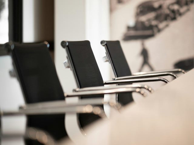 Chairs around a table in an office conference room.