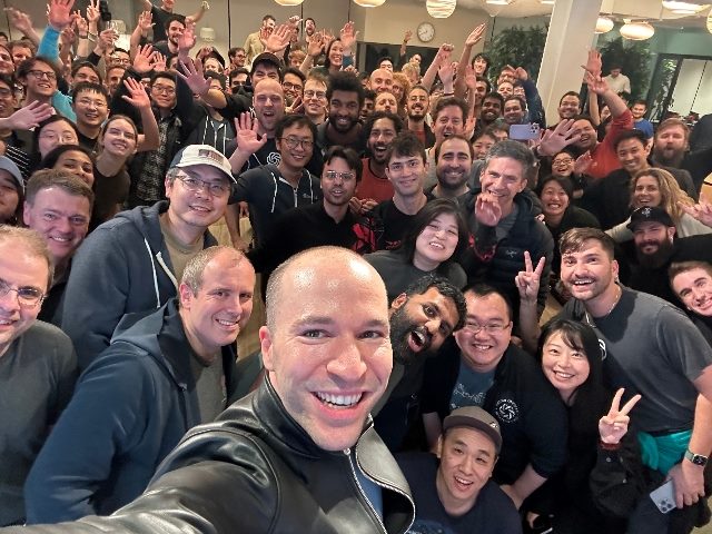 Greg Brockman, president and co-founder of OpenAI, in a selfie with him and dozens of other OpenAI employees. OpenAI rehired Sam Altman as CEO Wednesday, Nov. 22, five days after it fired him.