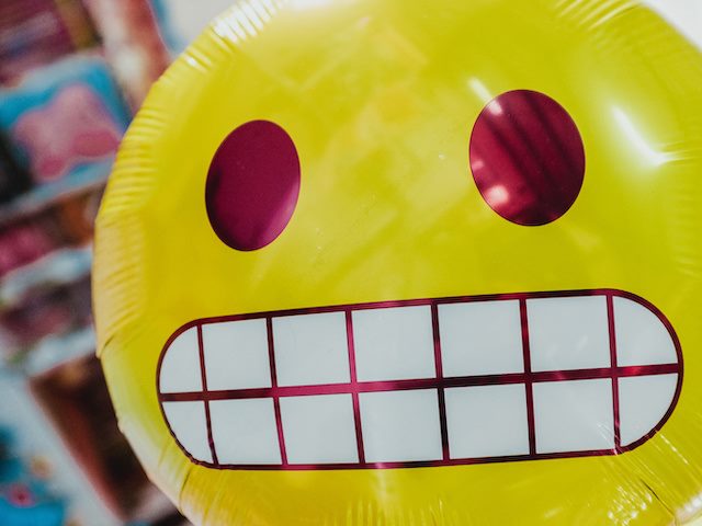 emoji balloon: smiling or grimacing?