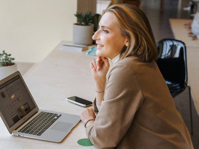 An employee works on a laptop computer in an open office.