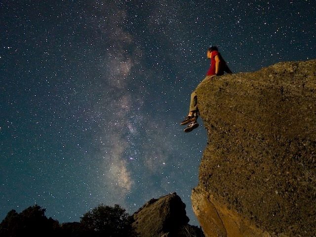 sitting alone, contemplating the stars in the night sky