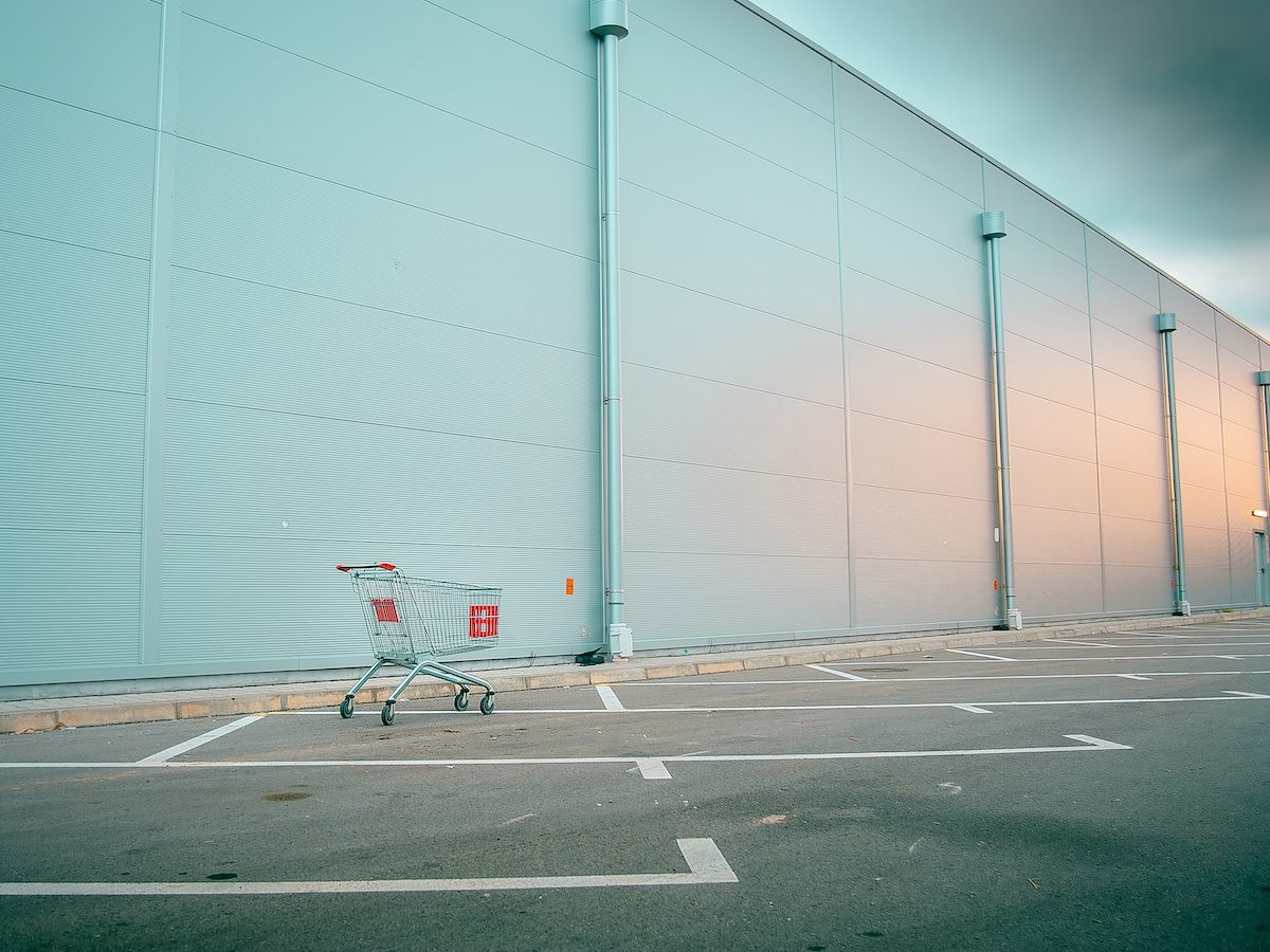 A shopping cart in an empty parking lot
