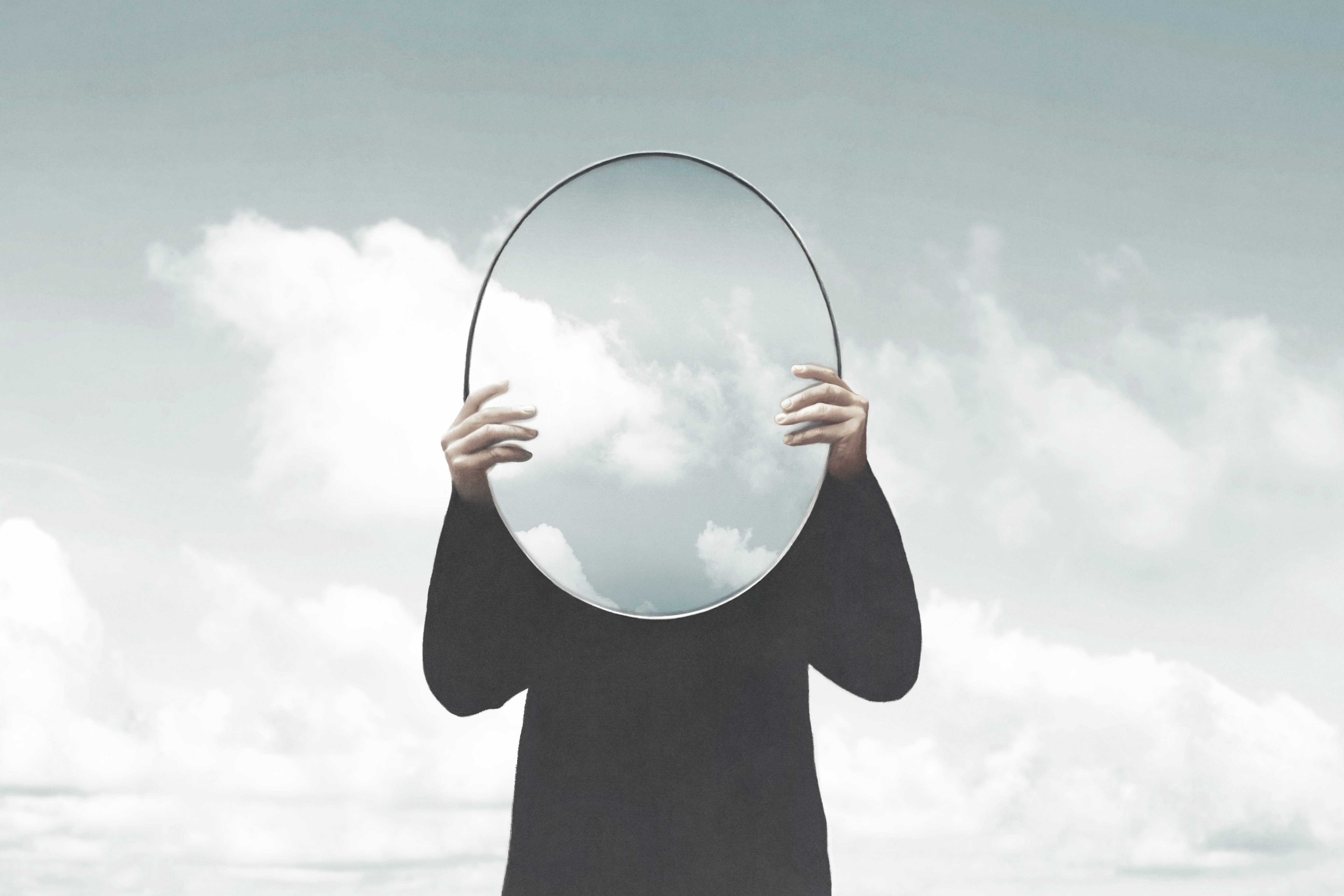 A person holding a mirror in front of their face