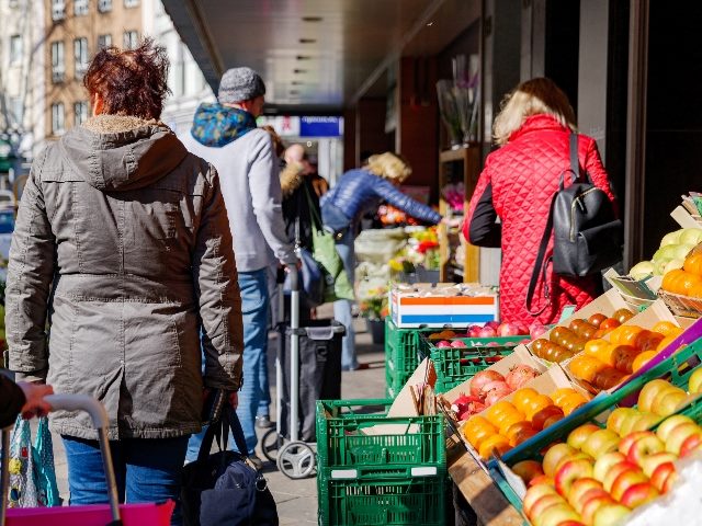 People wait in line outside in front of food stall and supermarket during quarantine for COVID-19 in Düsseldorf, Germany. 