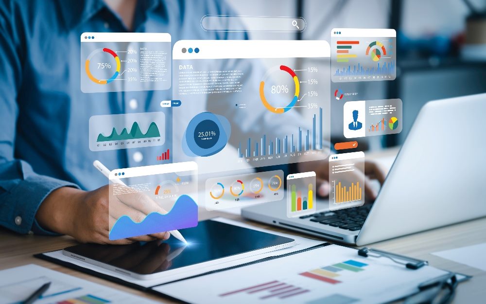 An analyst uses a computer and dashboard for data analysis and management with KPIs and metrics visible in piece about the impact of AI in marketing.