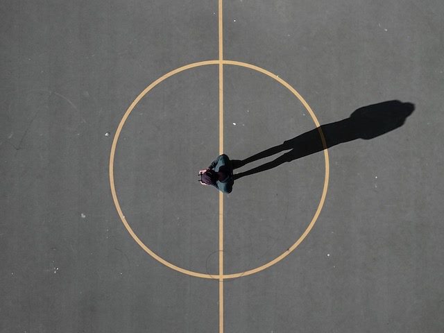 person standing in the middle of a circle on the pavement