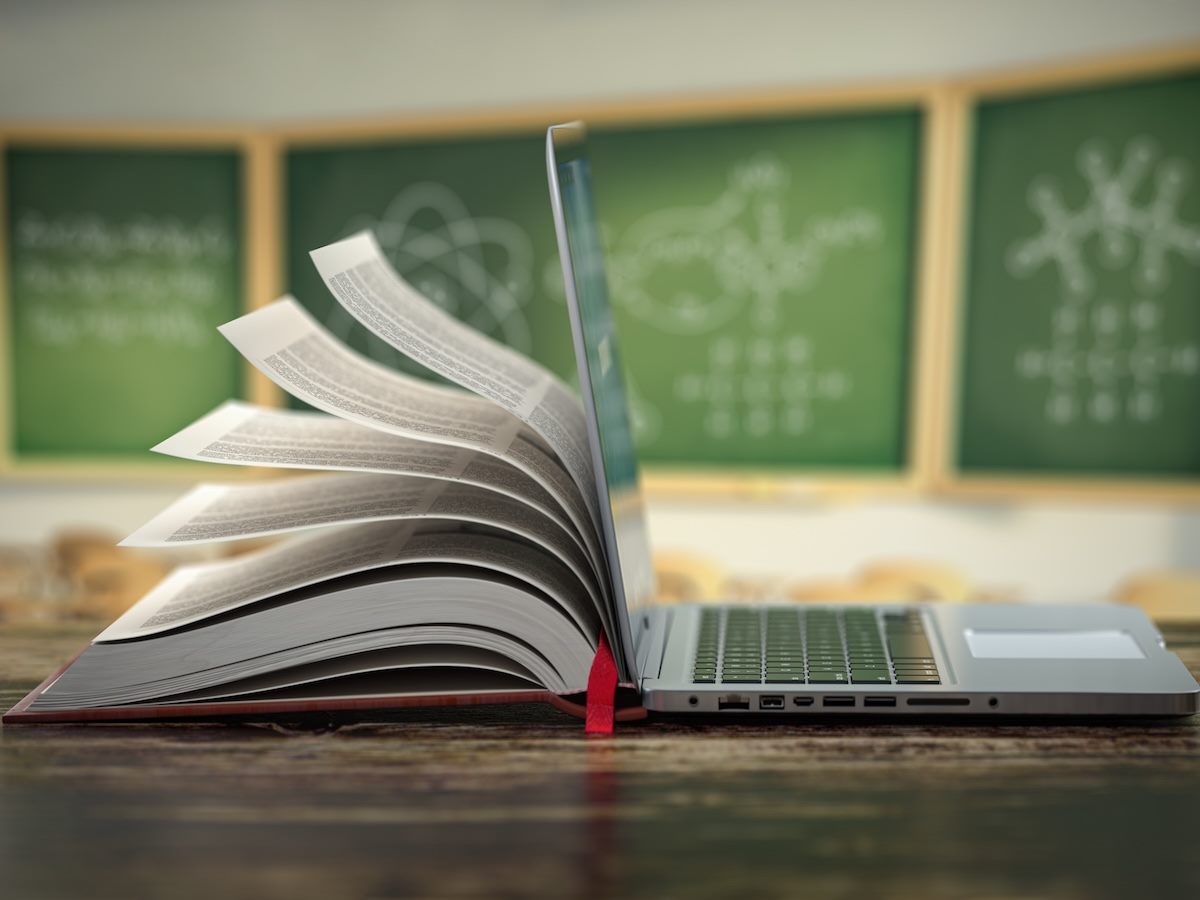 Open laptop and book compilation in a classroom