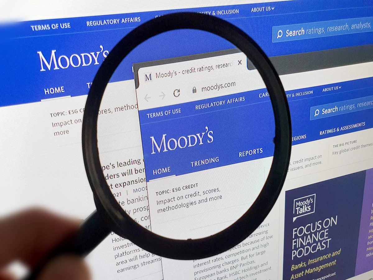 Photo of Moody's homepage on a monitor screen through a magnifying glass. 