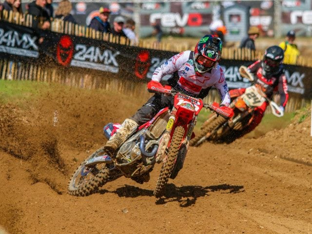 A motocross rider turns on a race track.