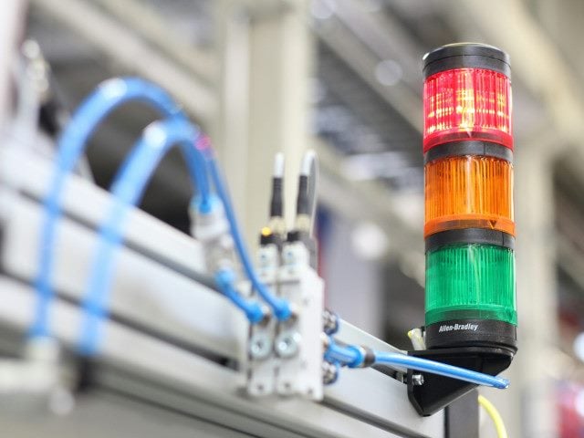 A red-orange-green signal safety light in a factory.