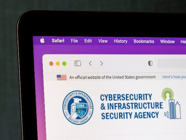 A laptop computer screen shows the homepage of the Cybersecurity and Infrastructure Security Agency (CISA), a federal agency.