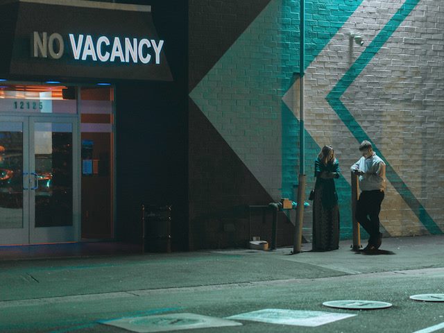 hotel sign with "No Vacancy" — the word Vacancy is lit up