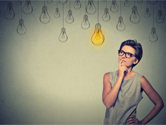 Businesswoman considering the ramifications of AI marketing project, with idea/lightbulb over her head