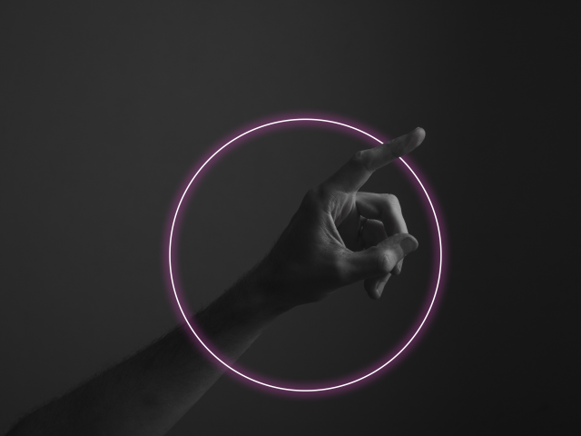 Hand pointing a finger against a dark background with abstract neon light glow