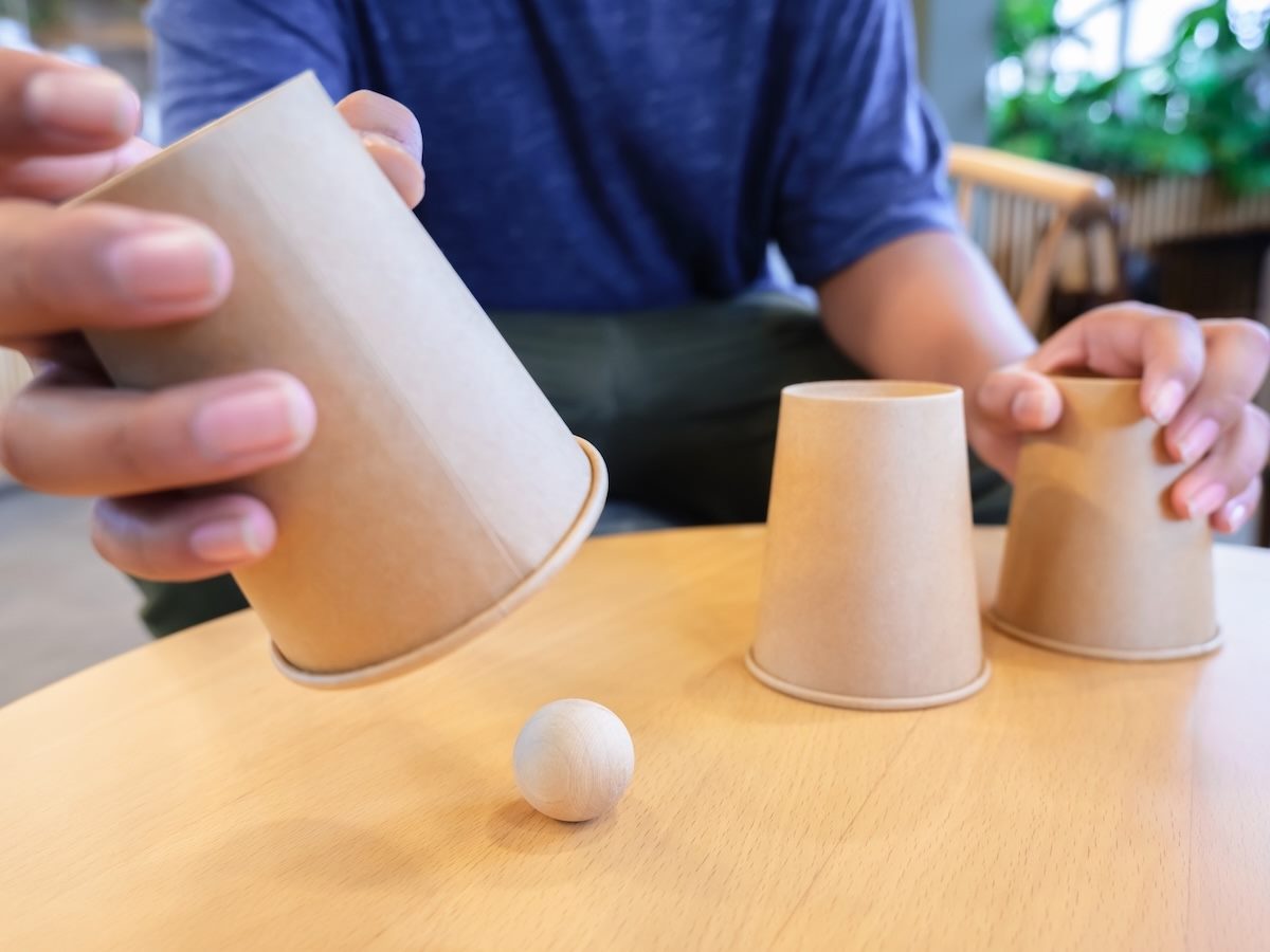 a person playing the shell game