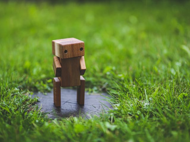 robot carved out of wood standing in the grass