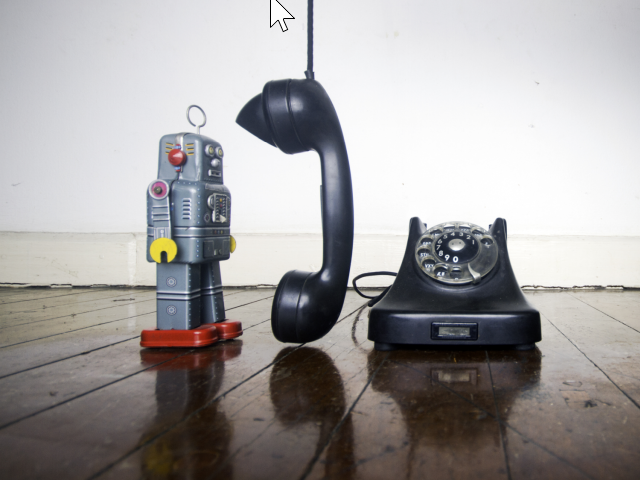 A retro robot with a vintage black phone - conversational AI in the call center concept