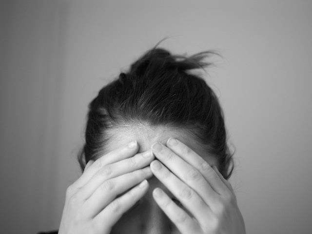 woman holding her head in hands, perhaps due to too many marketing emails?