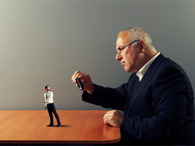 A giant CMO examining a customer through a magnifying glass - marketing personalization concept