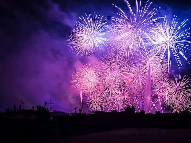 fireworks exploding over city rooftops