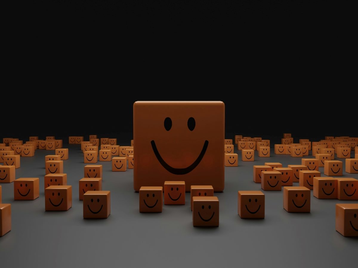 A big wood block with a smily face surrounded by dozens of little ones.