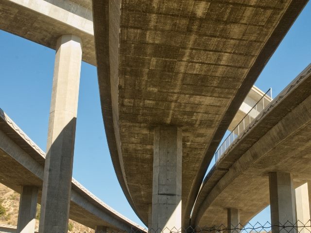 View of overhead curving freeway ramps against a blue sky, suggesting the complexities of new technology adoption. 