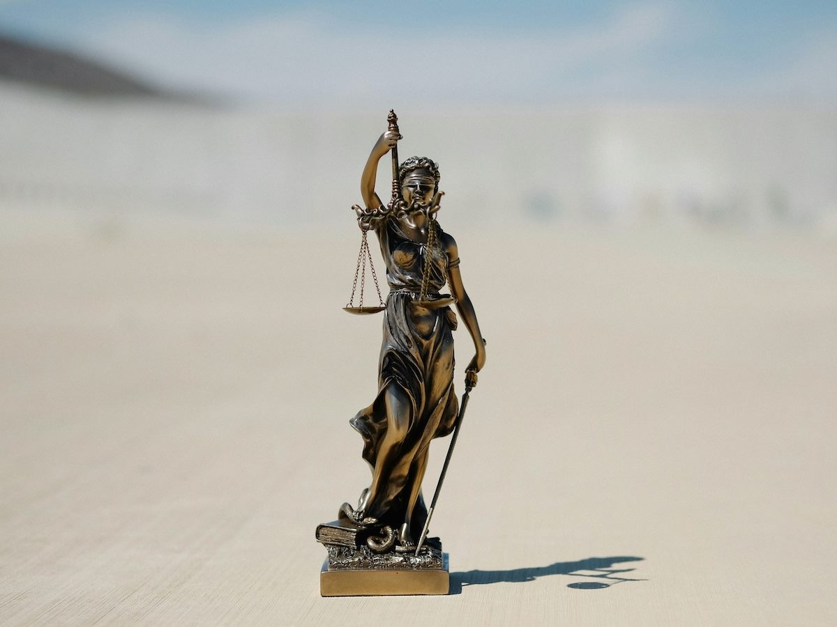 close up of a justice is blind statue on the ground 