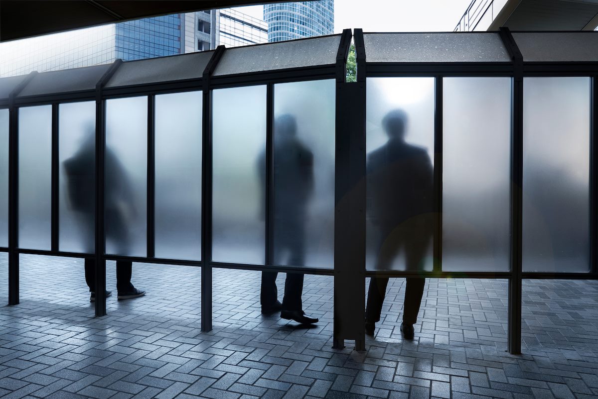 People standing behind clouded glass