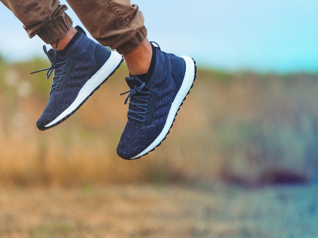 man's feet in sneakers jumping in air 