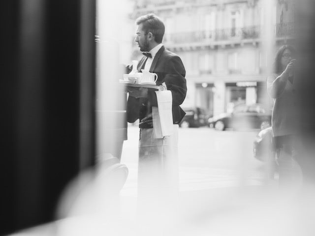 waiter in tuxedo with white cloth draped over arm