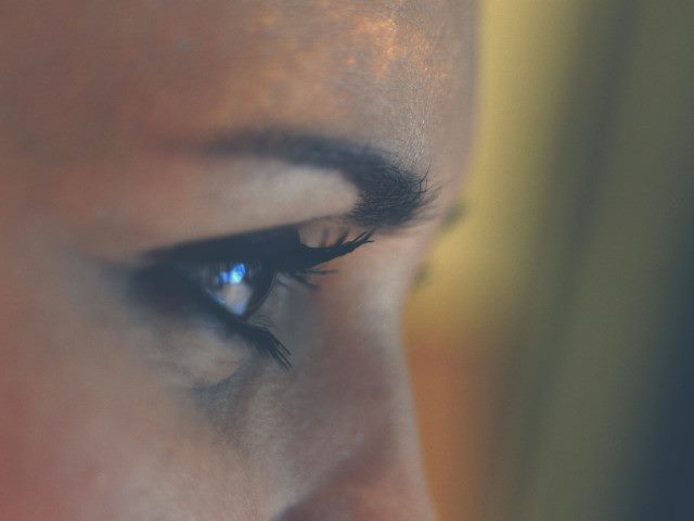 A side profile of a person's eye and eyebrow.