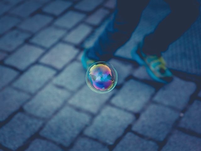 bubble on sidewalk in front of person's legs