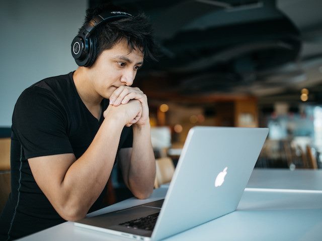 man watching a webinar on his laptop