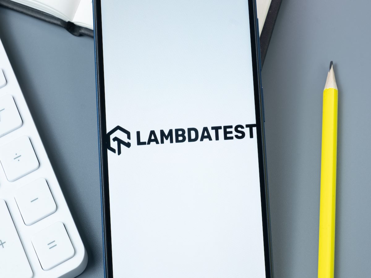 The LambdaTest logo on a smartphone