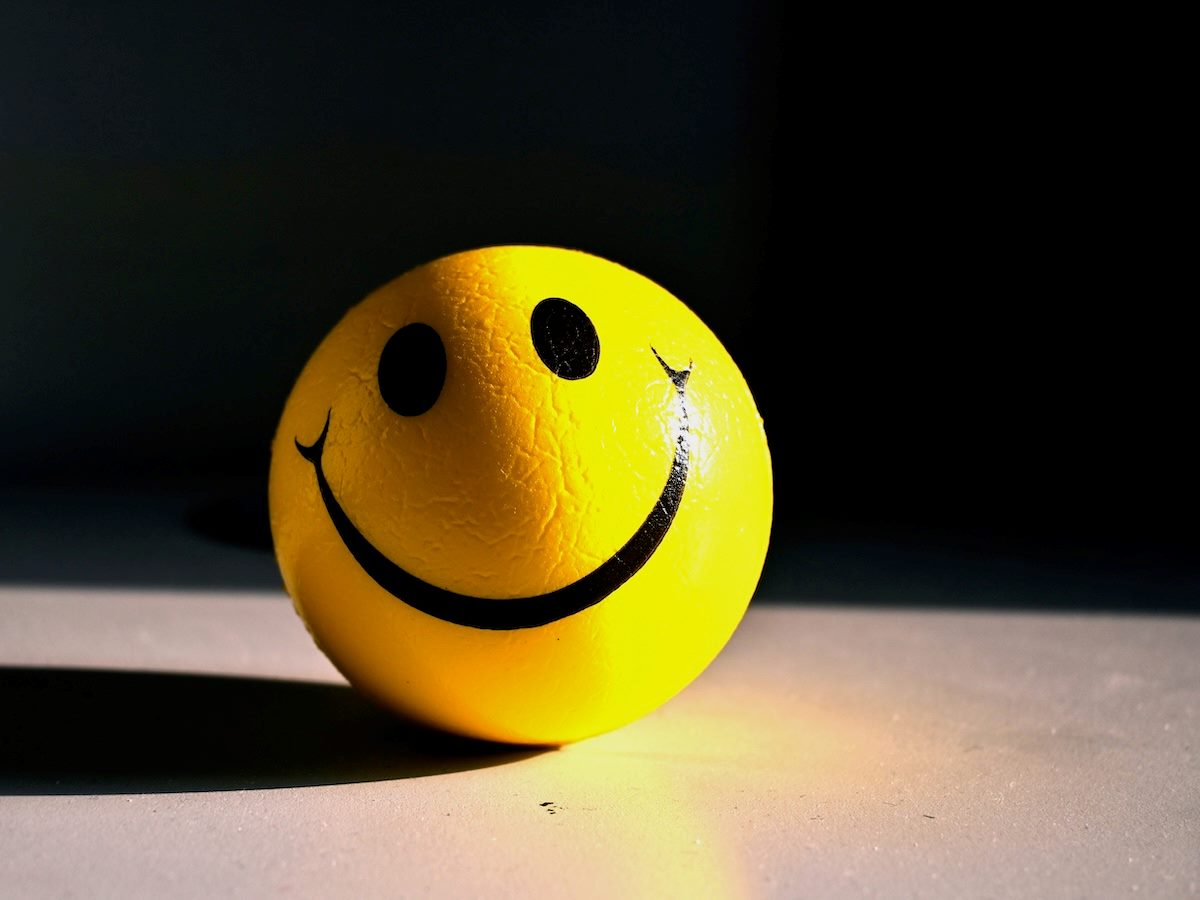 slightly worn, smily face stress ball