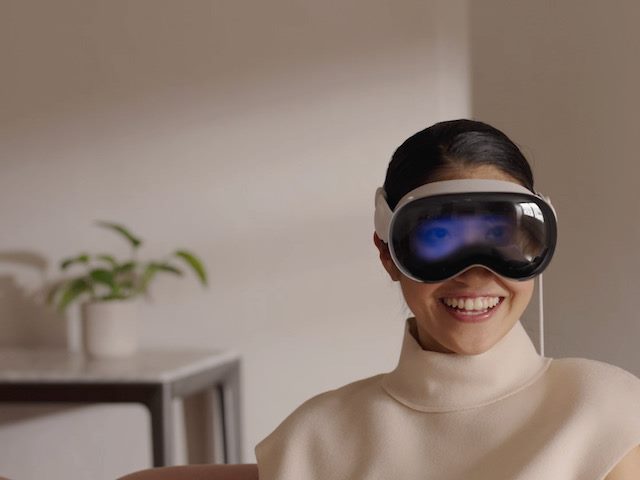 woman wearing Vision Pro interacting with the physical space around her