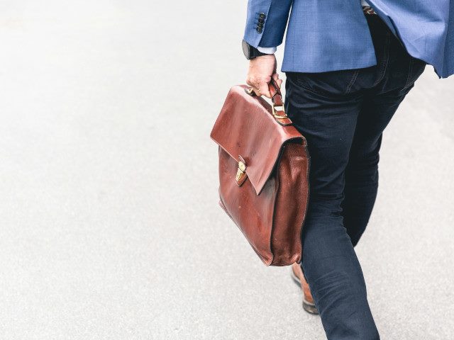 An employee walks with a briefcase.