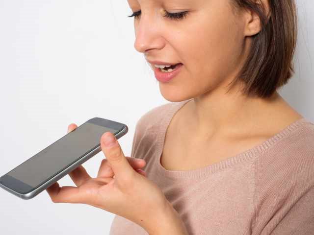Young woman using voice search to answer a question