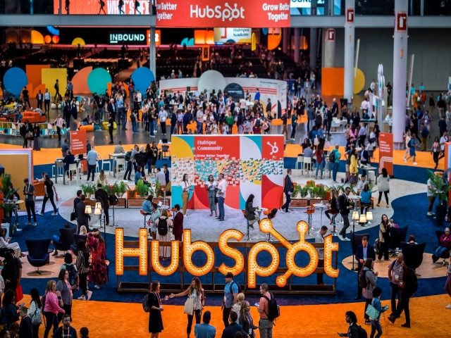 A photo of HubSpot's Inbound conference showing attendees milling about a signs that reads HubSpot.