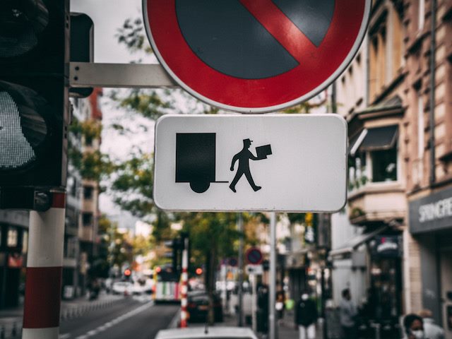 delivery sign under a stoplight