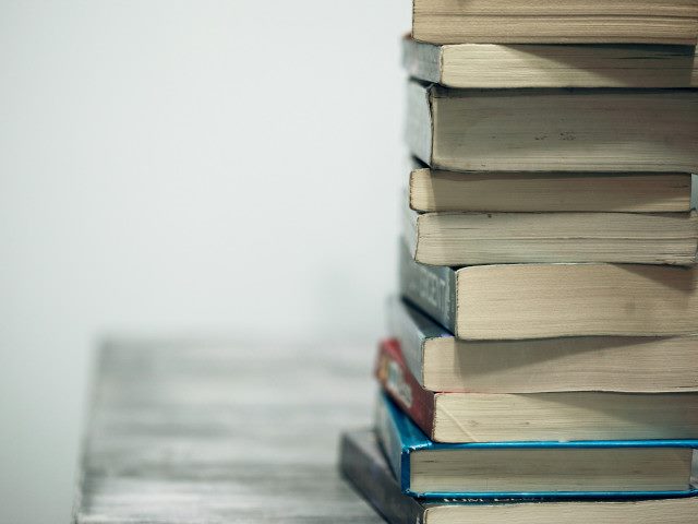 A stack of textbooks on a table.