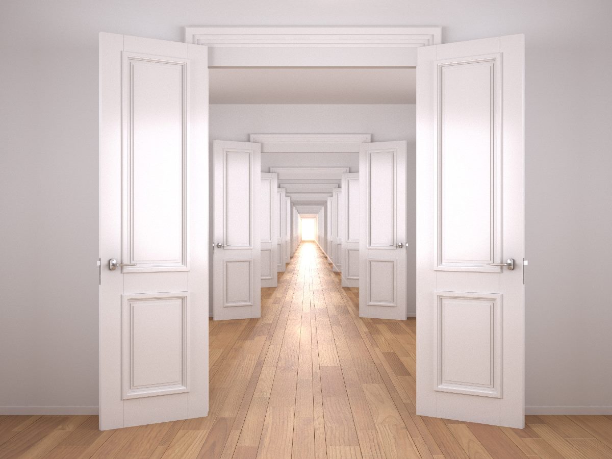 A long hallway with a series of identical white doors standing open in perfect alignment, creating a repeating visual corridor that leads toward a bright vanishing point at the far end.