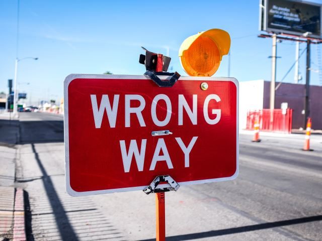 A wrong way sign on the road way before construction - negative impact concept