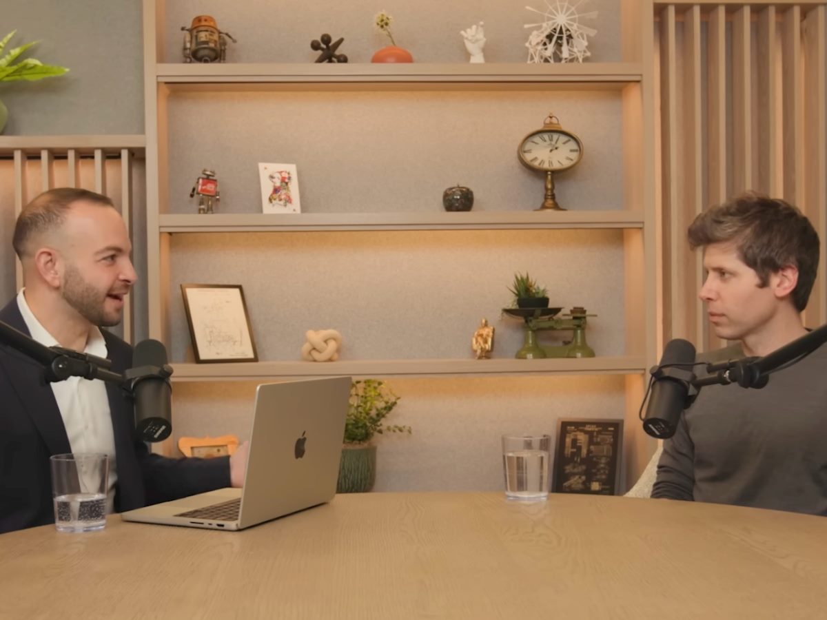 Alex Kantrowitz, left, interviews Sam Altman, as the two sit down with podcast mics.