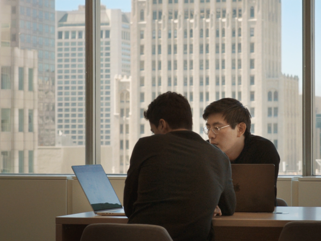 Screenshot of OpenAI AI engineers working with a laptop computer in San Francisco, California.