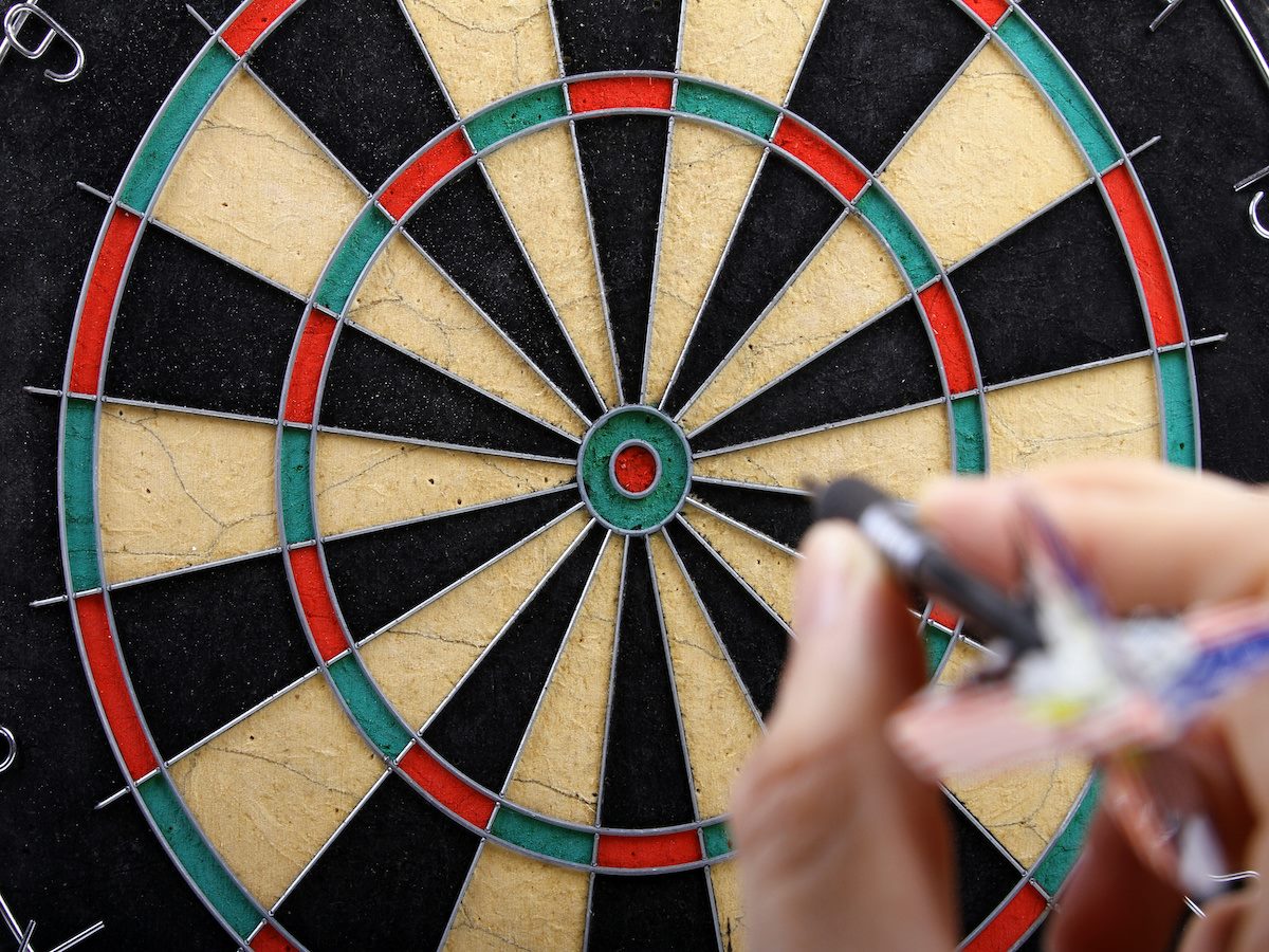 A person throwing a dart at a dartboard 