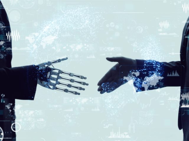 Shaking hands of a businessperson and a robot. - AI and employee experience concept